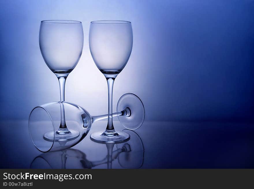 Three empty wine glasses on blue background