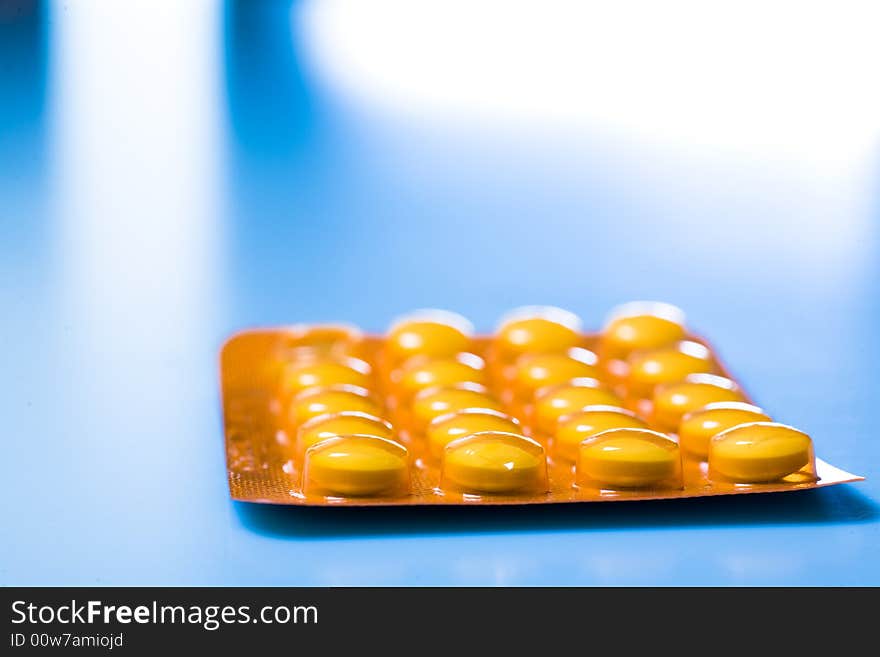 Pills on blue background; Shallow depth of field.