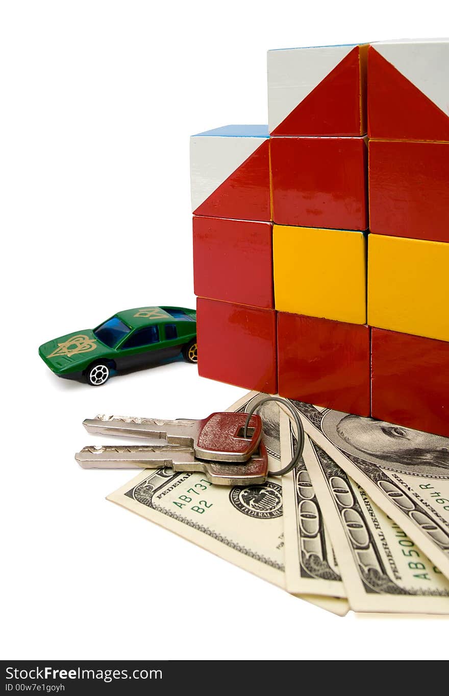 Toy house, toy car and keys over a bunch of dollars, over white, isolated with clipping path. Toy house, toy car and keys over a bunch of dollars, over white, isolated with clipping path