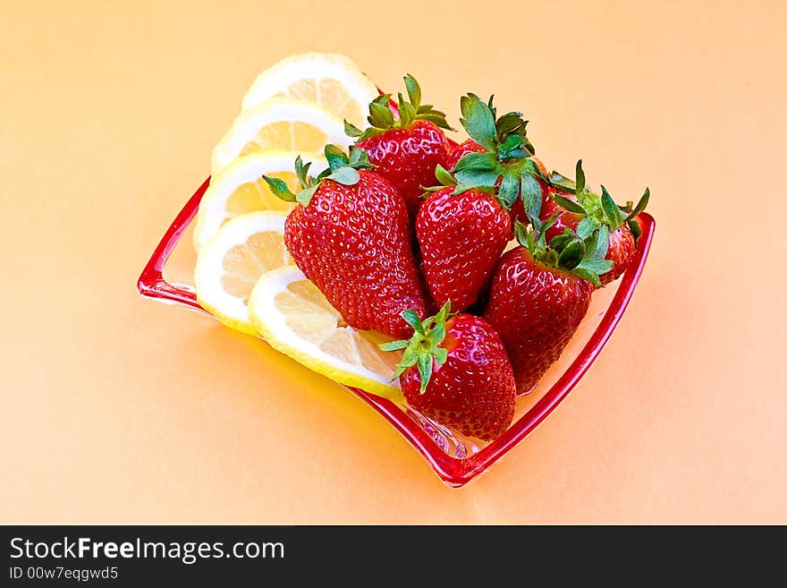 Lemons and strawberry on the glass saucer. Lemons and strawberry on the glass saucer