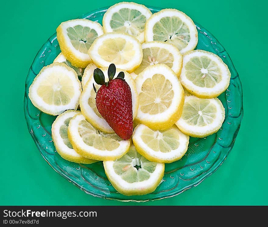 Lemons and strawberry on the glass saucer. Lemons and strawberry on the glass saucer