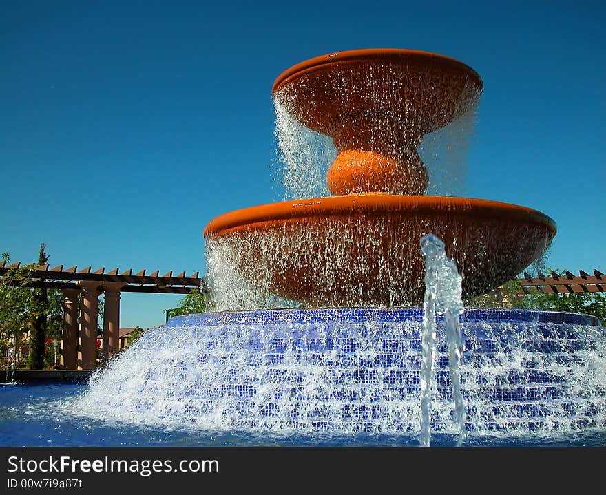 A large water fountain with cascading base surrounded by an arbor in master planned community. A large water fountain with cascading base surrounded by an arbor in master planned community.