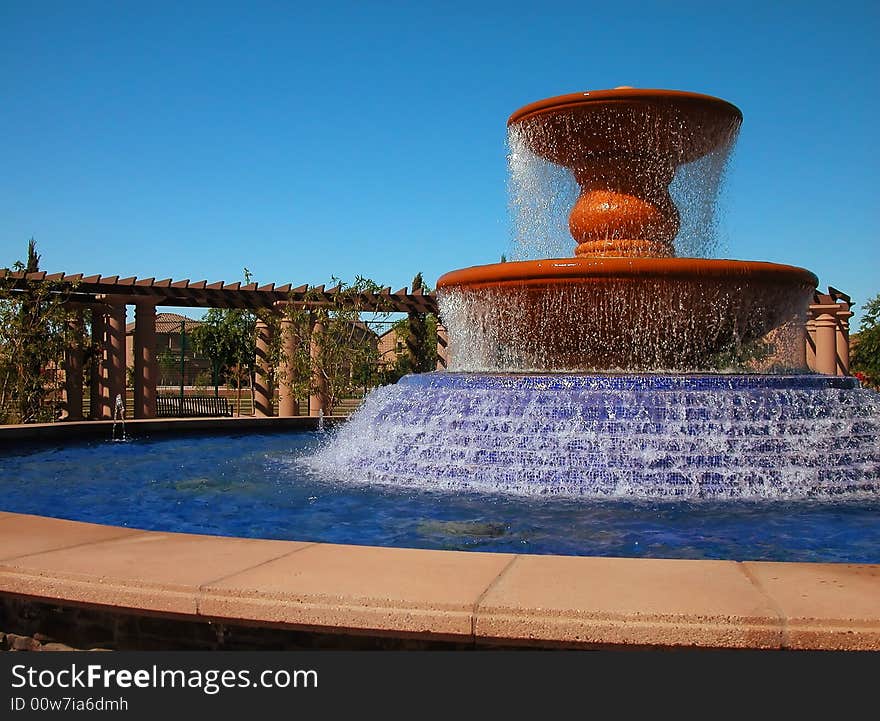 A large water fountain with cascading base surrounded by an arbor in master planned community. A large water fountain with cascading base surrounded by an arbor in master planned community.