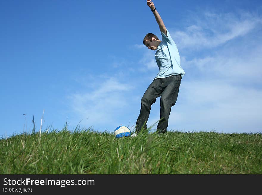 Young boy playing football on grass