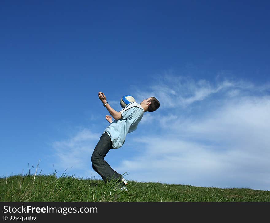 Young boy playing football on grass