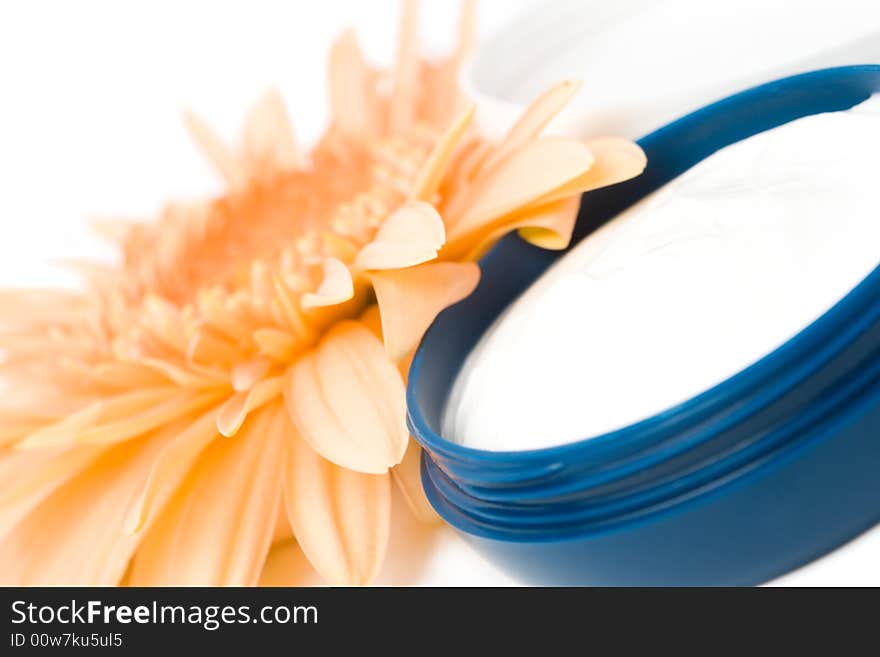 Moisturizing cream with orange gerbera close up