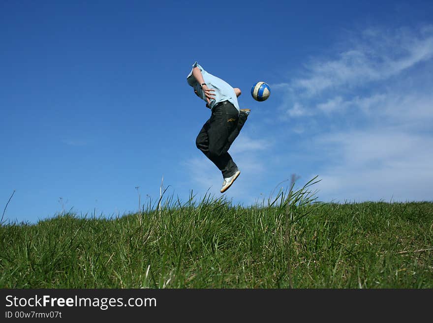 Young boy playing football on grass