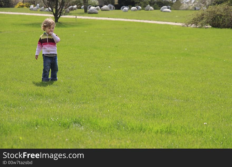 A child having a lollipop in the green garden. A child having a lollipop in the green garden.