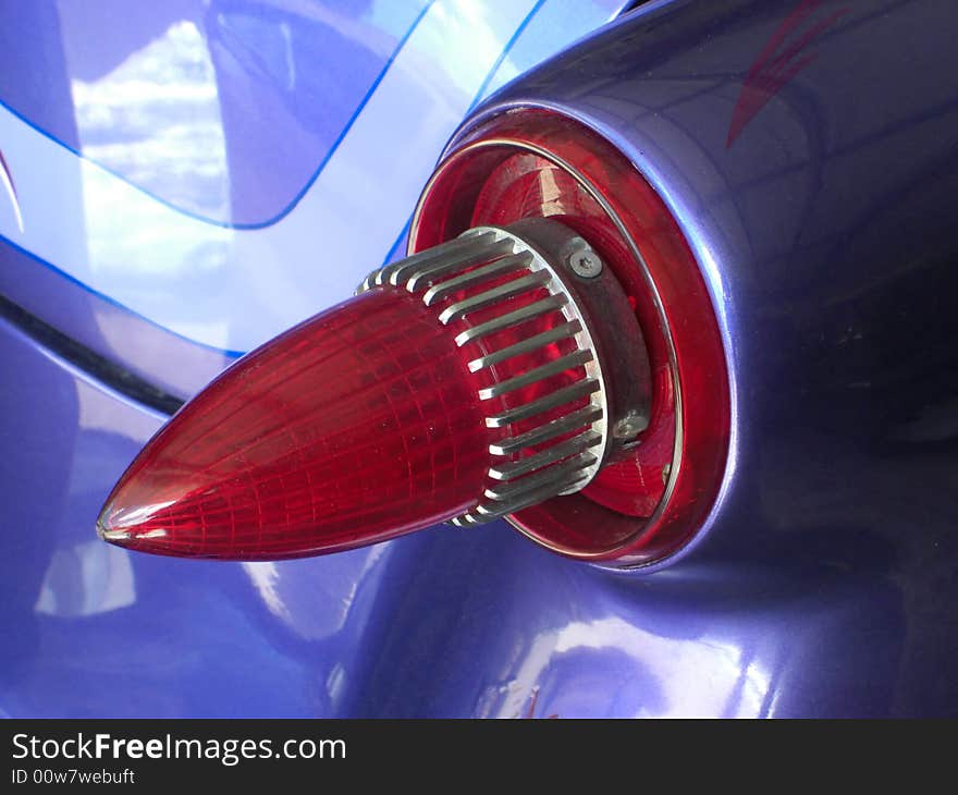 This is a tail light in a form of a bullet and belongs to a purple 1954 Ford Victoria. This is a tail light in a form of a bullet and belongs to a purple 1954 Ford Victoria.