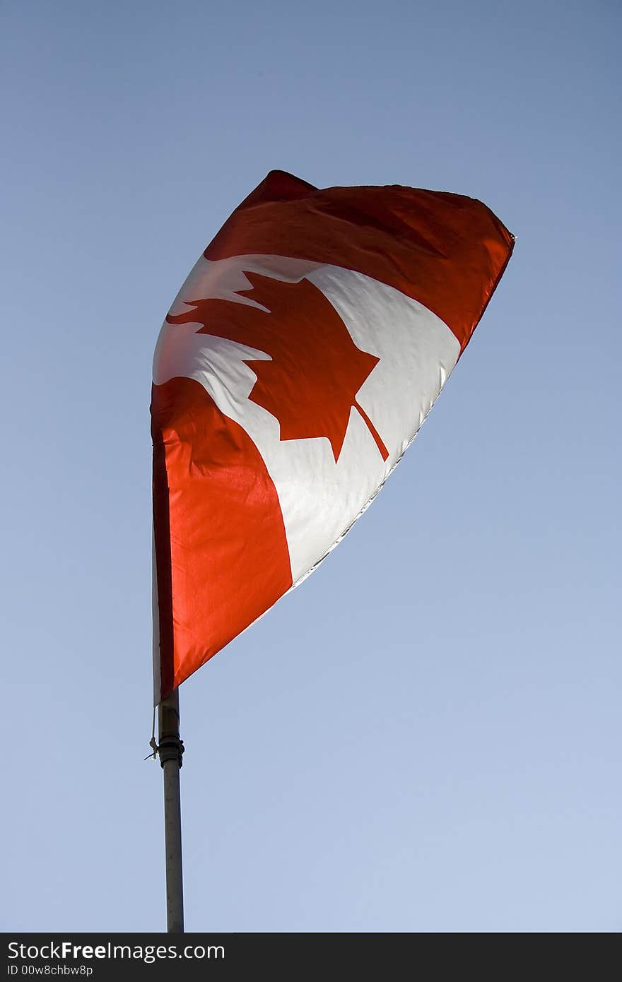 Canadian flag flying in a blue sky