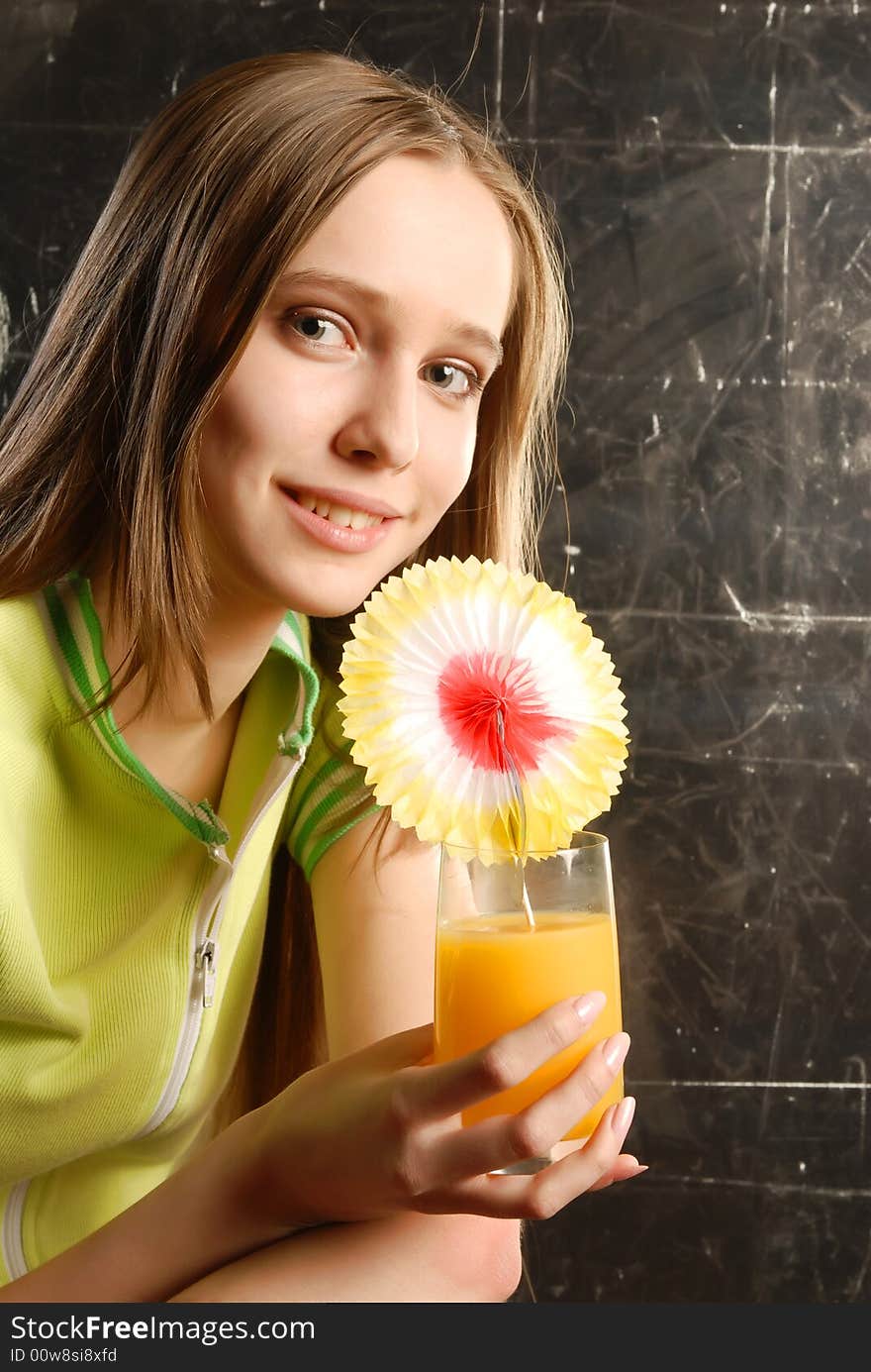 Beautiful teen girl holding an orange juise