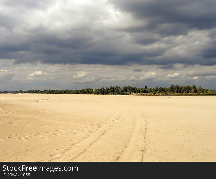 Low level of water in Vistula river show a large sand territory. Car tracks on first plan. Low level of water in Vistula river show a large sand territory. Car tracks on first plan.