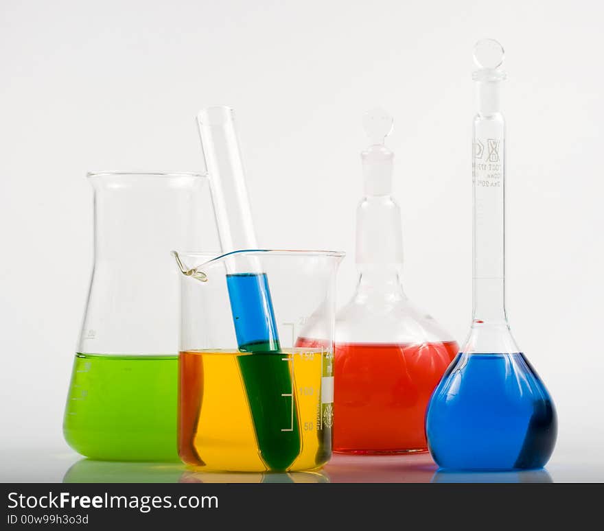 Various colorful flasks over white background