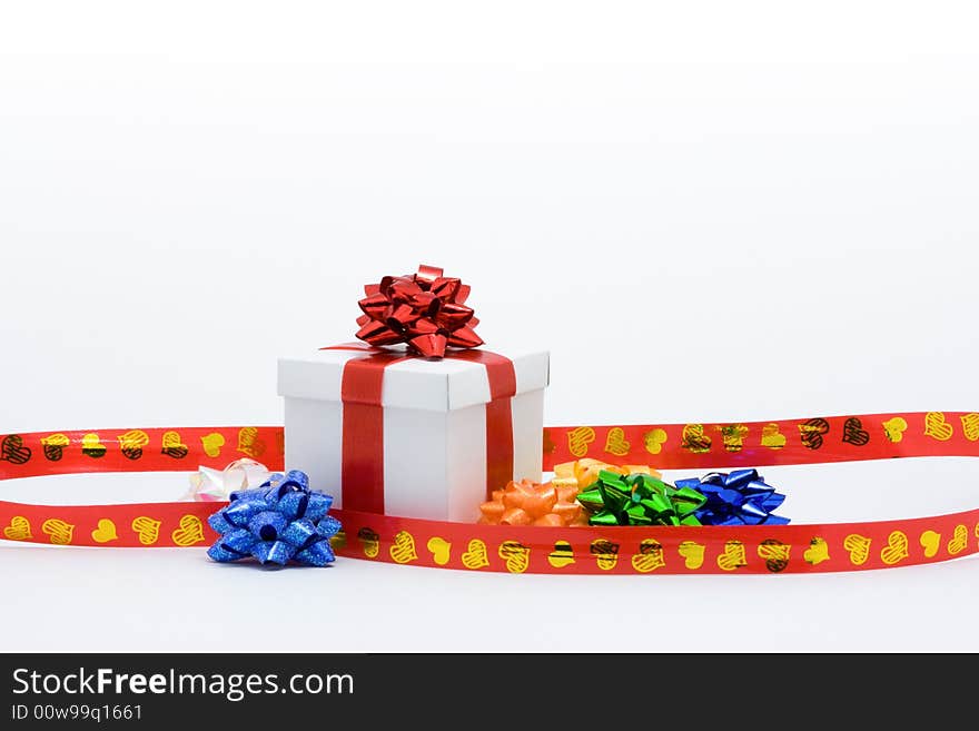 White fancy box with red ribbons over white background