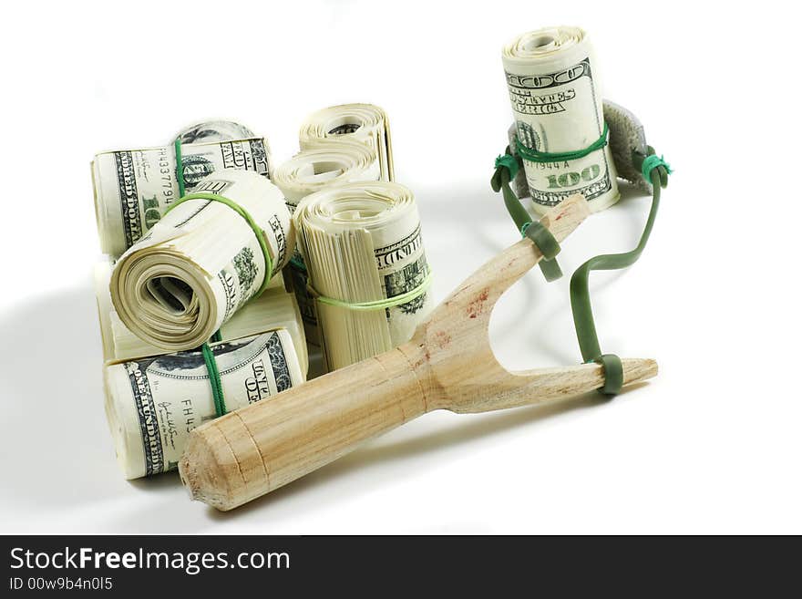 Slingshot on white with rolls of money. Slingshot on white with rolls of money