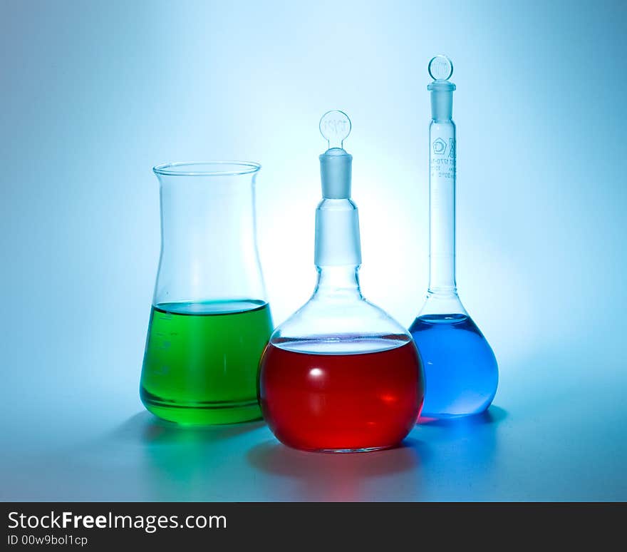 Various colorful flasks over blue tone background