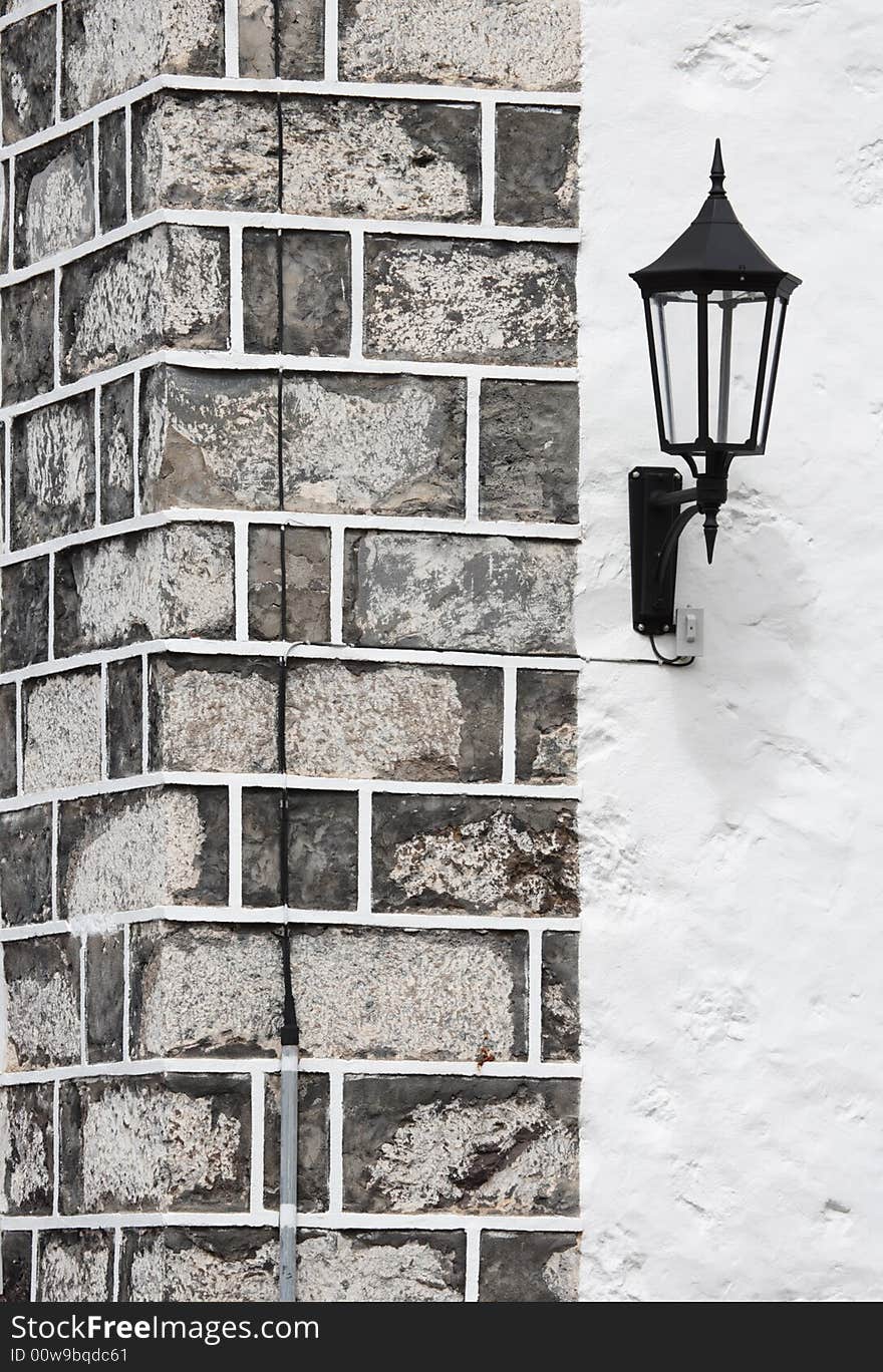 Street lamp and stone wall