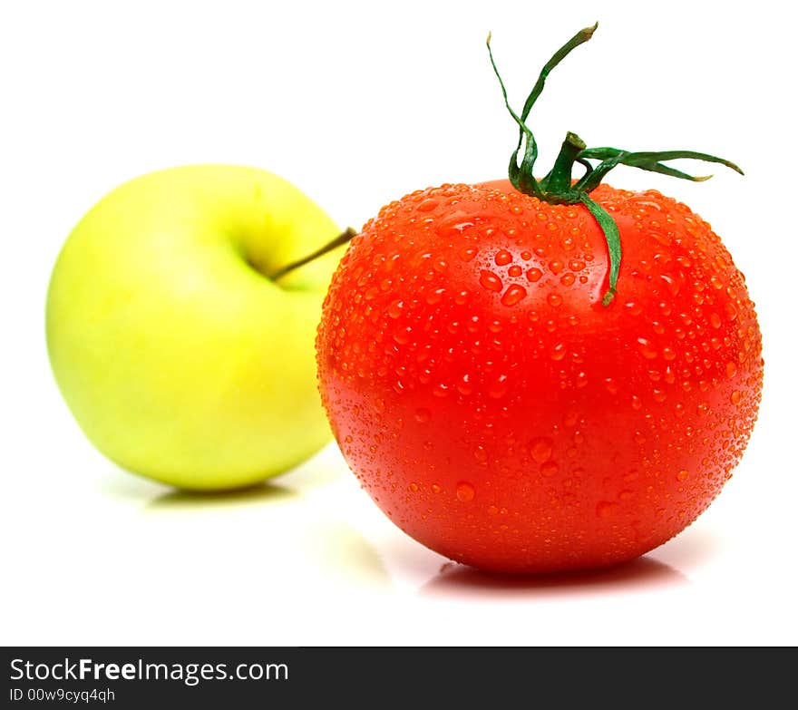 Yellow apple and tomato. Shallow DOF. Focus on a red tomato.