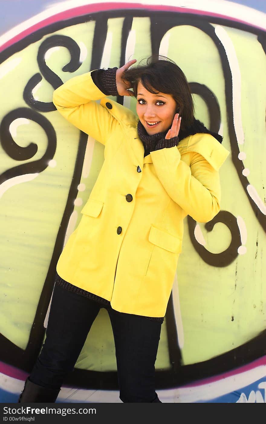 The cheerful girl on a background graffiti. The cheerful girl on a background graffiti