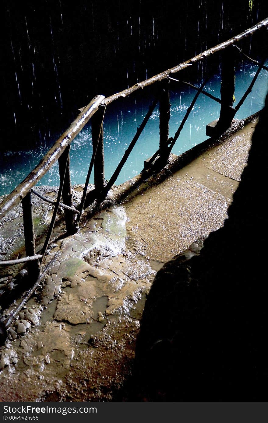 Stone path inside a grot with a wood balustrade and raining. Stone path inside a grot with a wood balustrade and raining