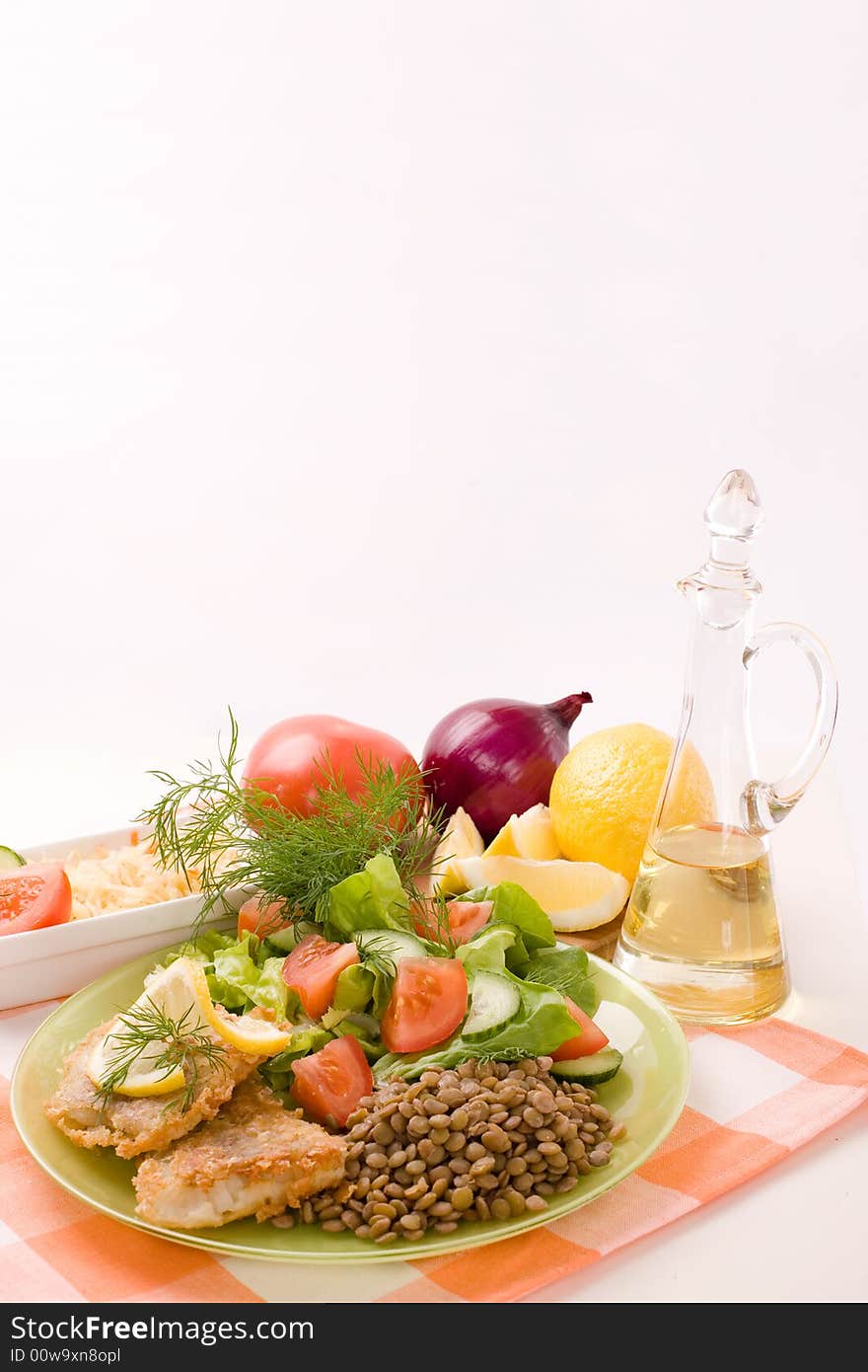 Fried fish fillets and fresh vegetables