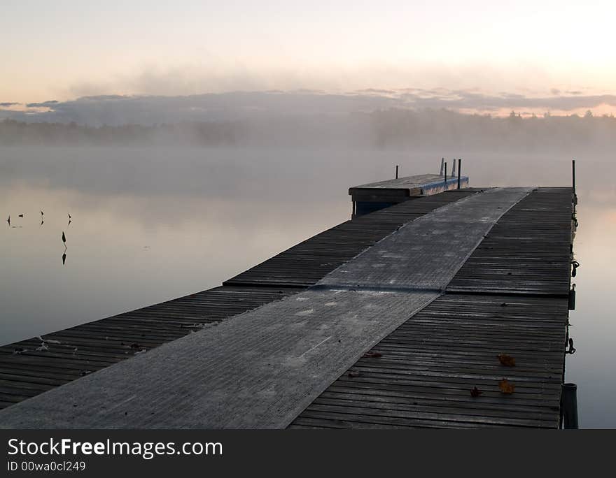 Quiet pier on a misty lake on an early autumn day. Quiet pier on a misty lake on an early autumn day.