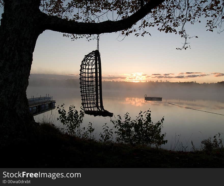 Hammok hanging in front on Lietash Lake on an cool foggy sunrise in autumn. Hammok hanging in front on Lietash Lake on an cool foggy sunrise in autumn.