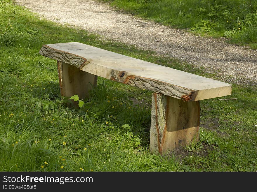 Rustic wooden bench on woodland walk, spring, May, UK. Rustic wooden bench on woodland walk, spring, May, UK.