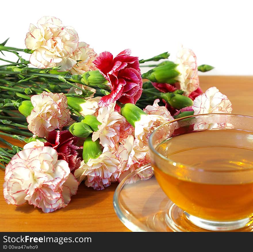 Cup of tea and bouquet of carnations isolated on a white background