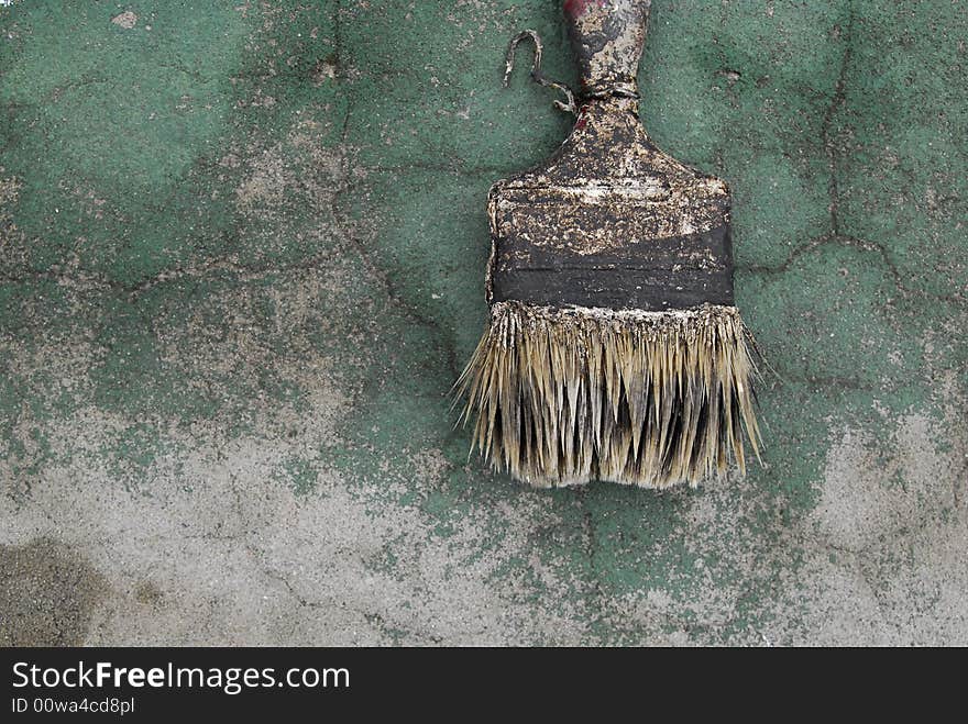 Old paintbrush in an old green wall