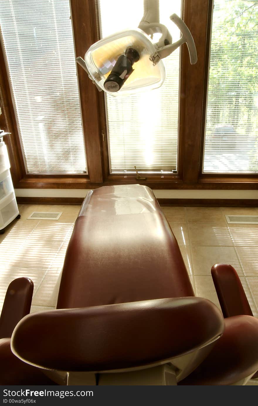 A red dental reclining chair at a dentists office. A red dental reclining chair at a dentists office