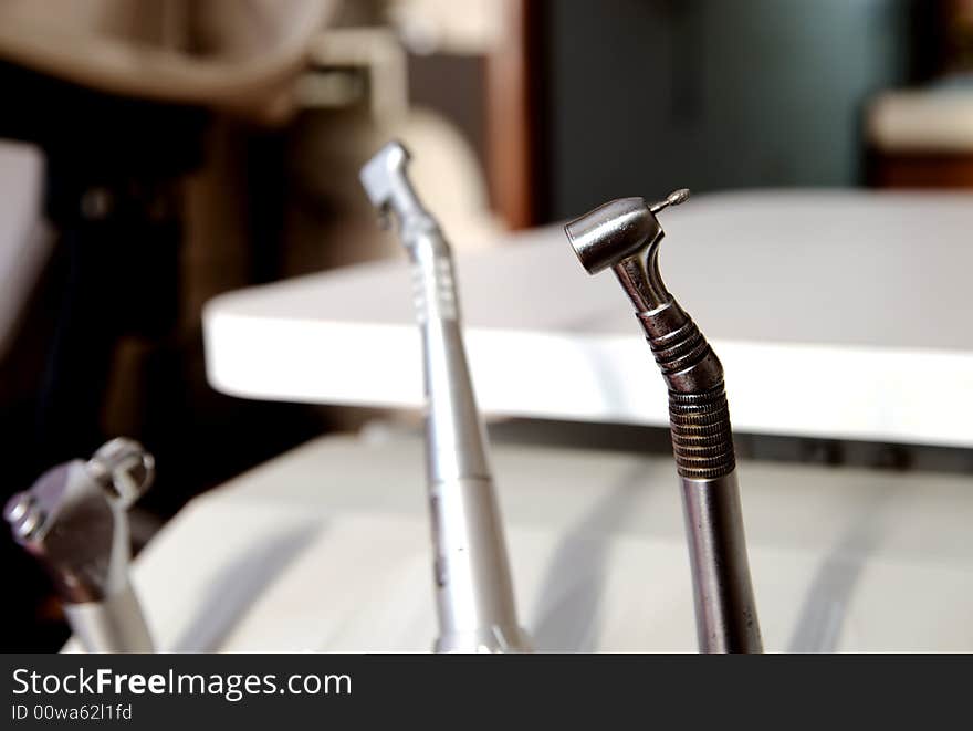 A dentists drill on a table in office room. A dentists drill on a table in office room.