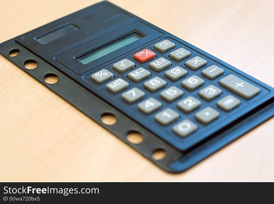 Pocket calculator on wooden desk