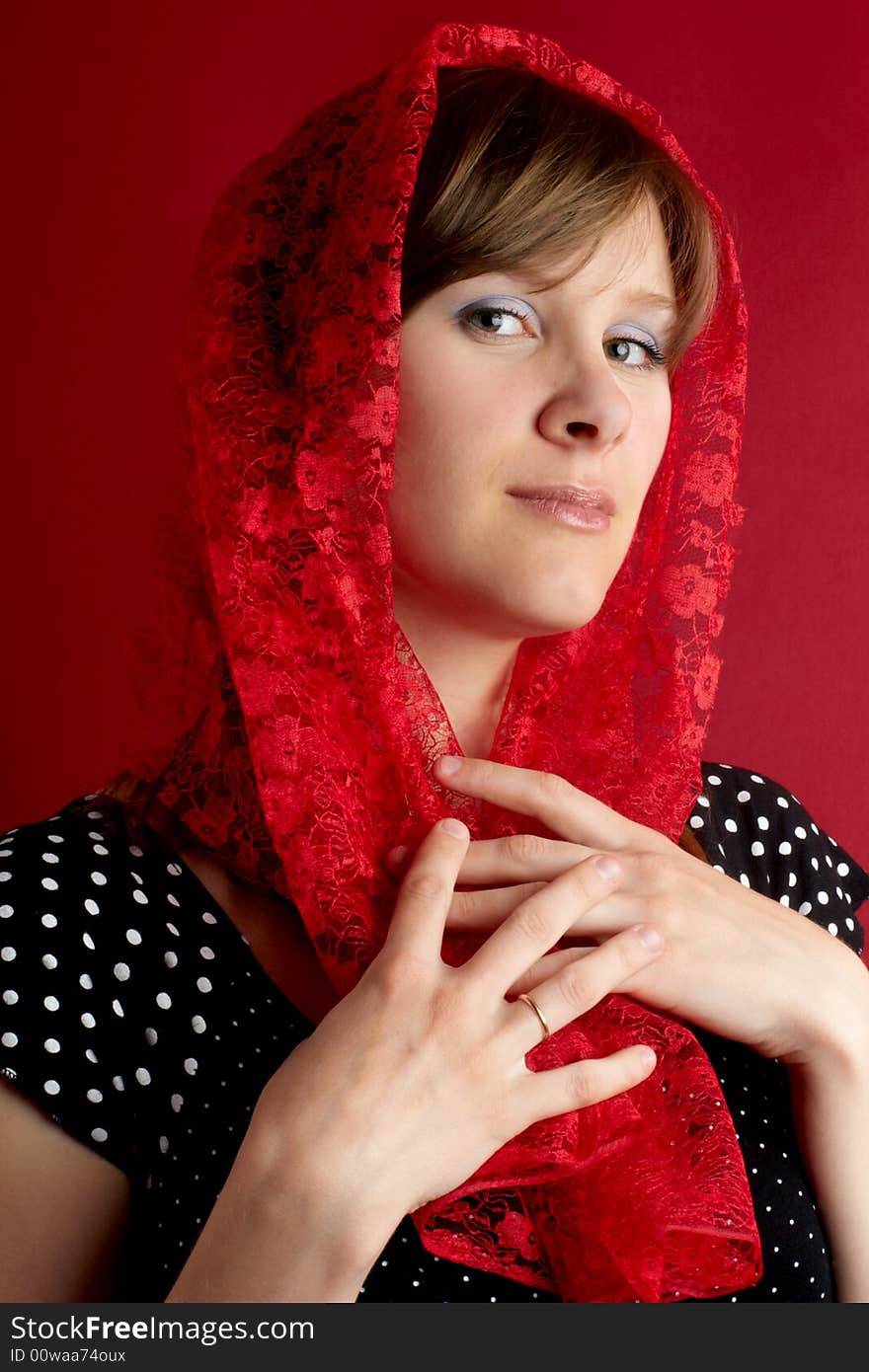 Pretty woman in red shawl on red background