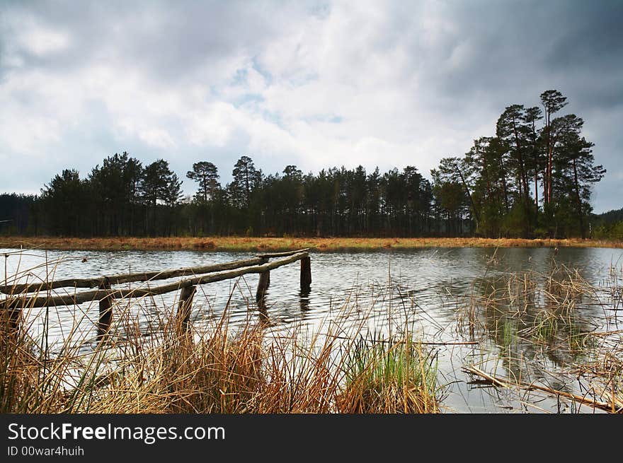 A lake in forest and dramatic sky