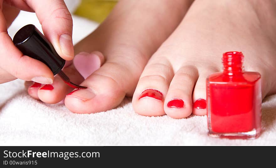 Red nail polish on her foot fingers. Red nail polish on her foot fingers