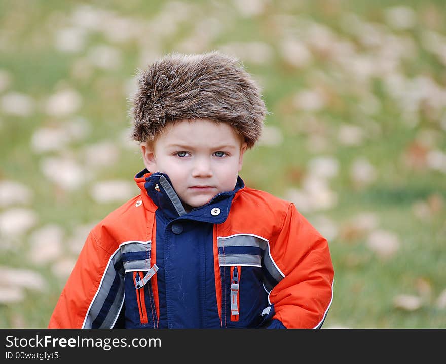 A small child in cold weather with a coon skin cap on. A small child in cold weather with a coon skin cap on