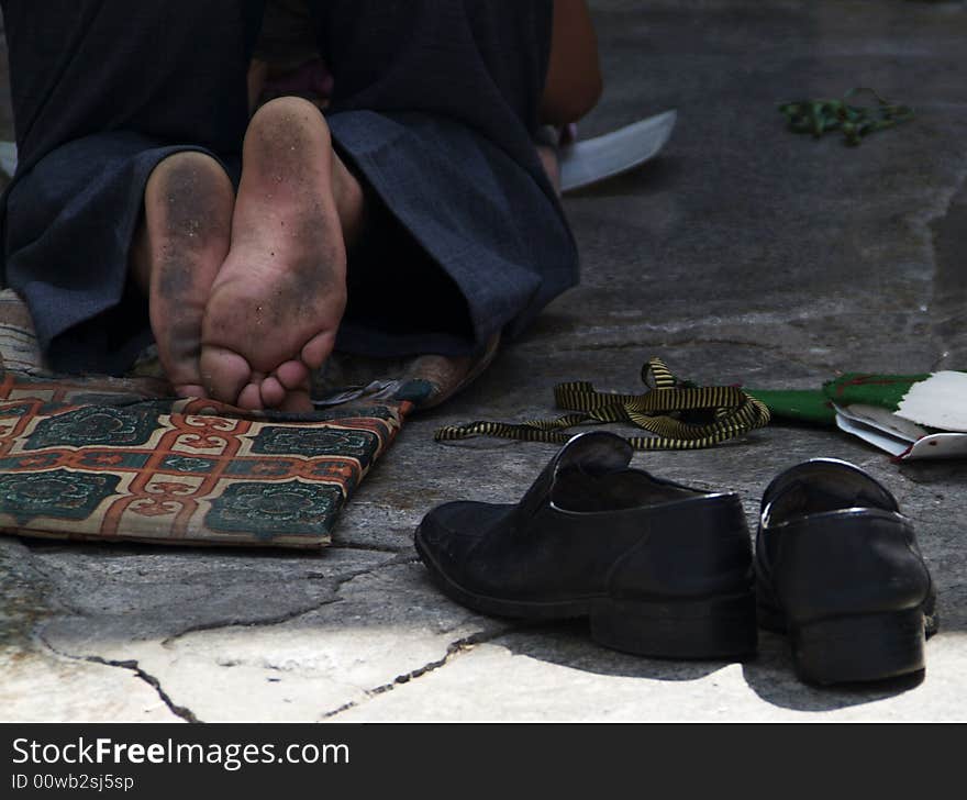 Bare feet of someone praying in front of the Jokhang Temple in Lhasa Tibet. Bare feet of someone praying in front of the Jokhang Temple in Lhasa Tibet