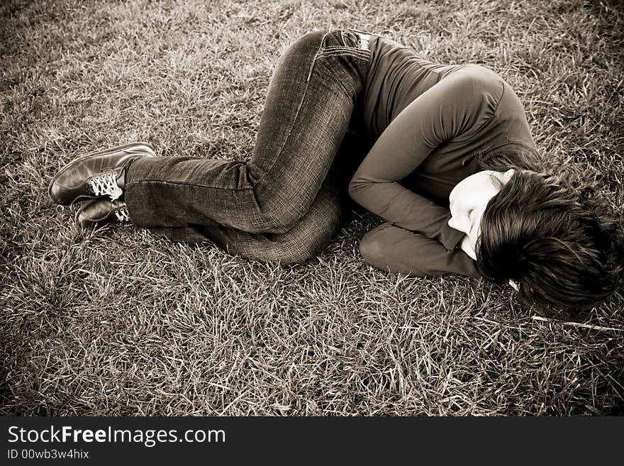 Young beauty sleeping over the grass, sepia toned. Young beauty sleeping over the grass, sepia toned.