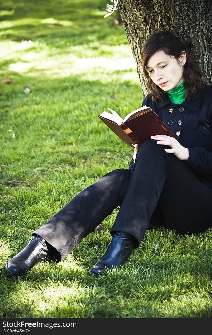 Young woman enjoying a book in the park. Young woman enjoying a book in the park