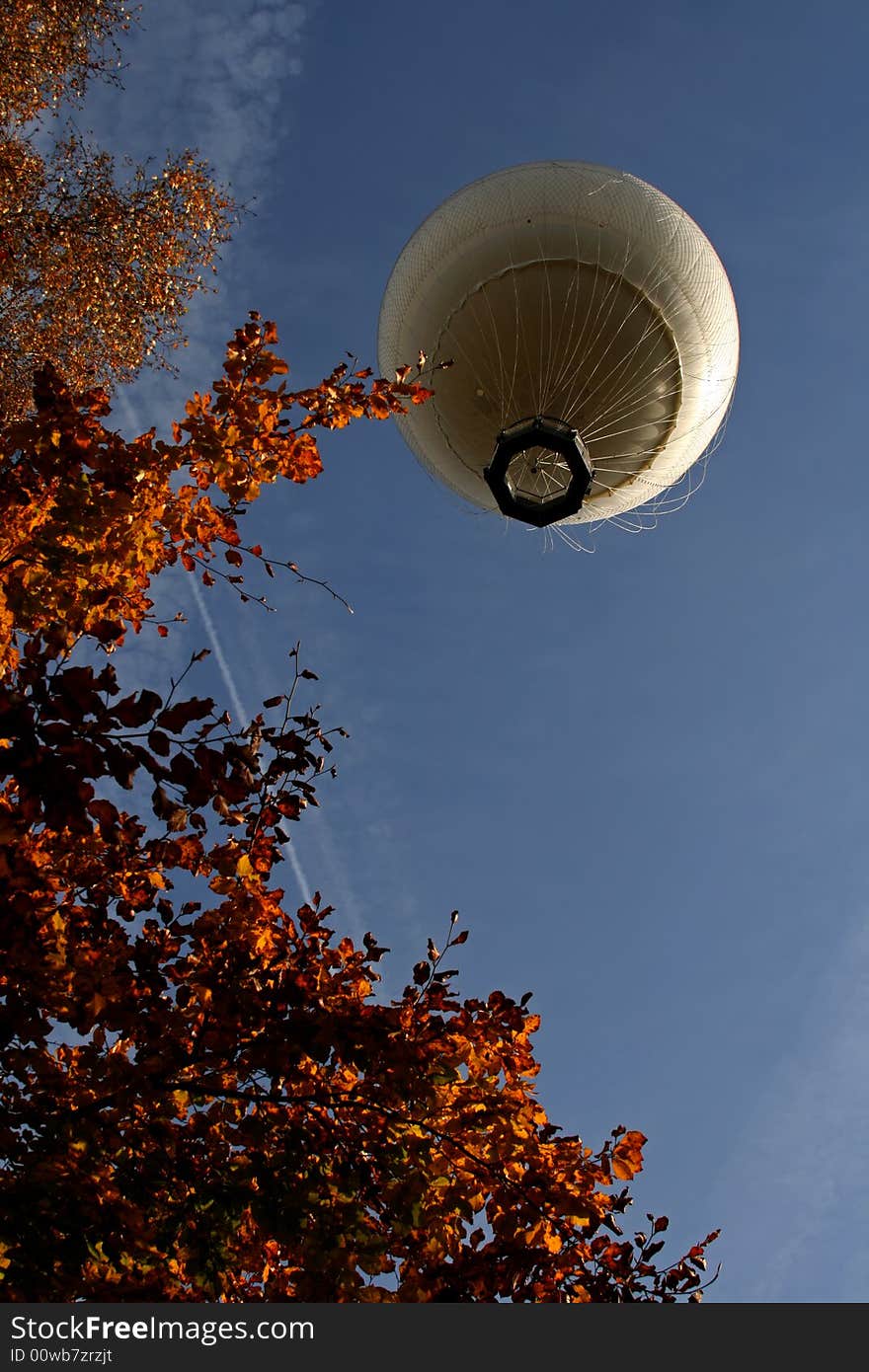 Looking up at a white hot air balloon in the air