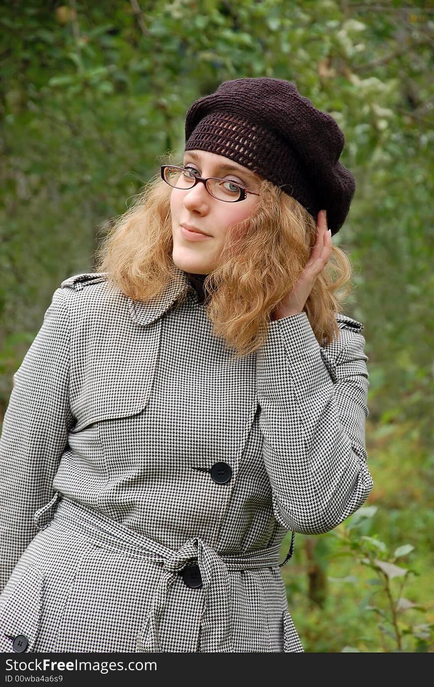 Beautiful girl in a coat over a green background