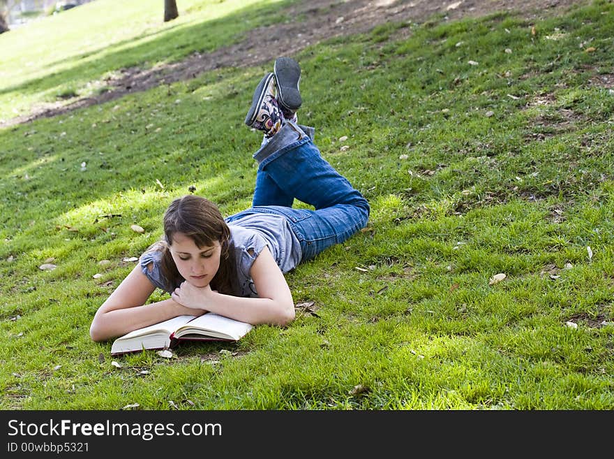 Young woman reading over the grass. Young woman reading over the grass.