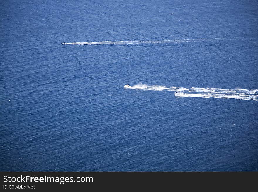 Motor boat and two aquatic motorcycles driving through the sea at aguilas murcia spain. Motor boat and two aquatic motorcycles driving through the sea at aguilas murcia spain