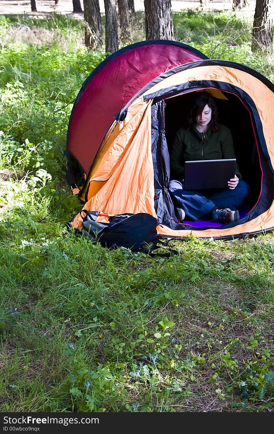 Young woman using laptop in the middle of the forest. Young woman using laptop in the middle of the forest