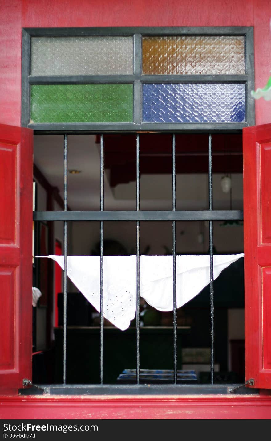 Red window frame with stained glass accents.