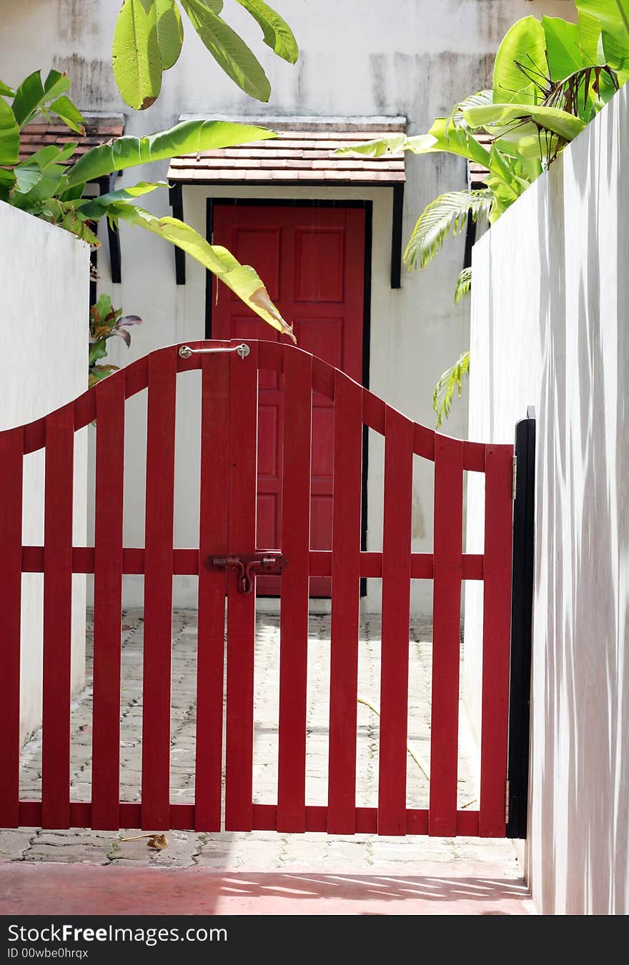 Pretty red fence and door at the entrance of a home. Pretty red fence and door at the entrance of a home.