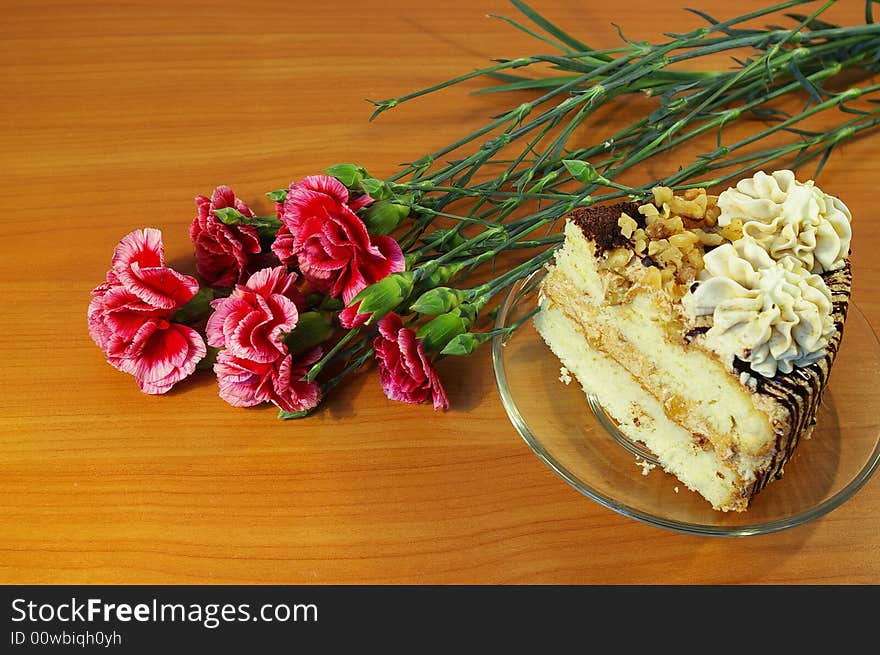 Bouquet of pink carnations and piece of a cake. Bouquet of pink carnations and piece of a cake