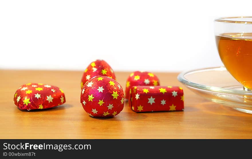 Chocolates in a red wrapper and a cup of tea