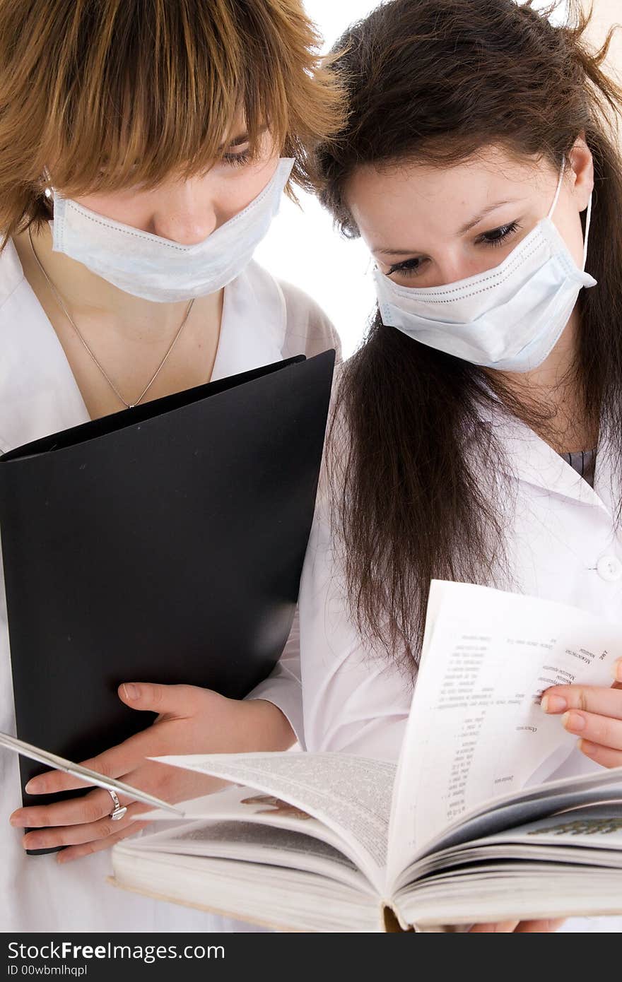 The two young attractive nurse with a documents isolated on a white background. The two young attractive nurse with a documents isolated on a white background